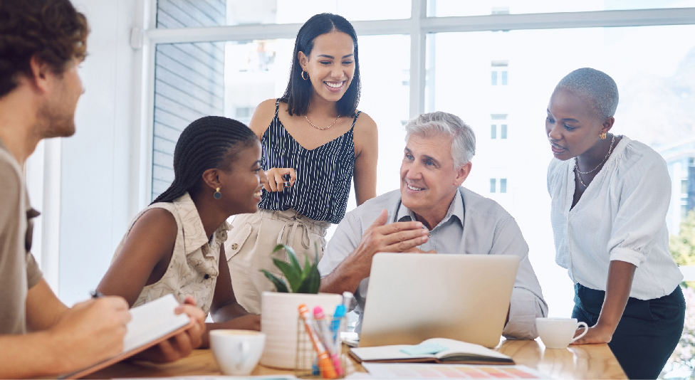 coworkers gathered around laptop