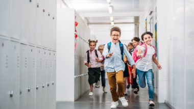 Pupils running through school corridor