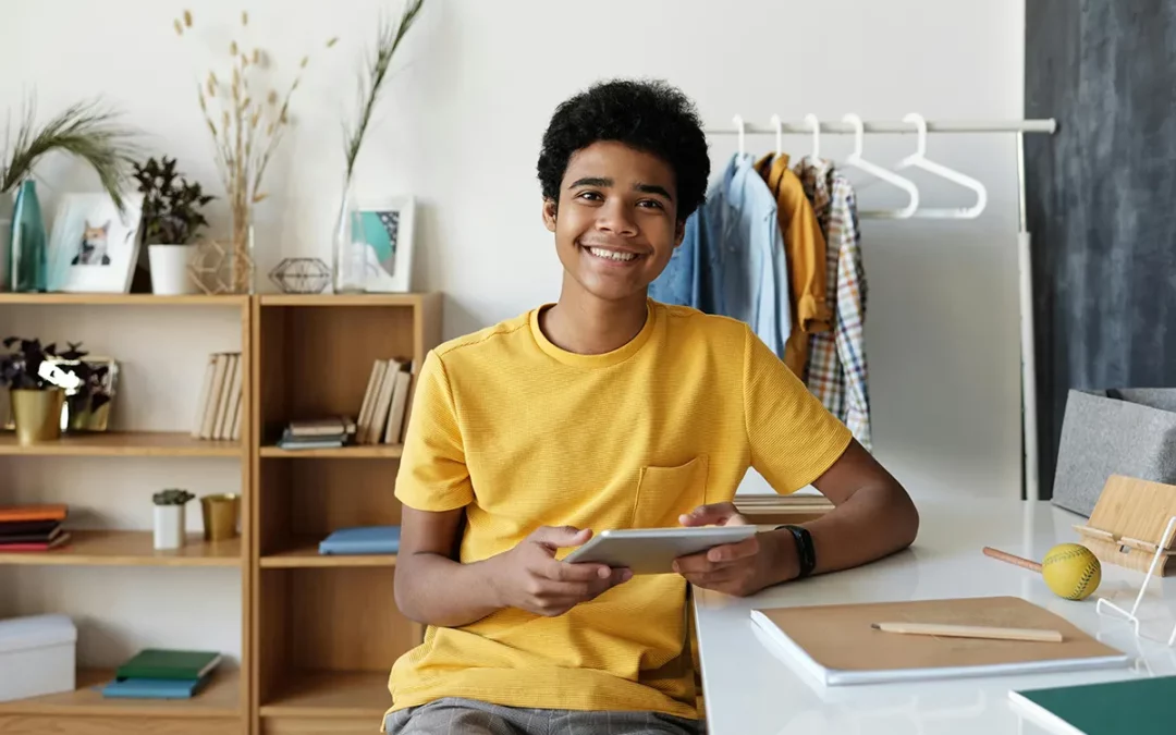 Boy sitting on chair wearing yellow crew neck t-shirt