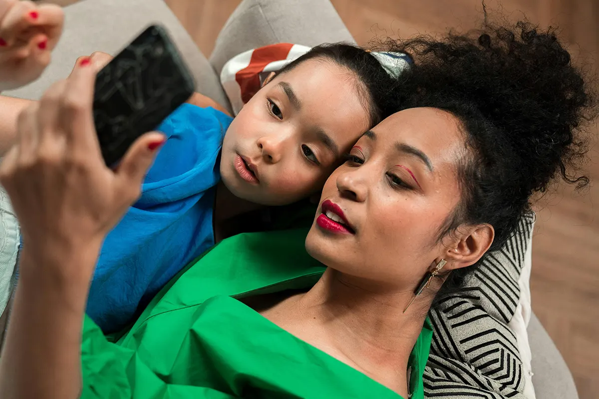 Woman in green shirt taking selfie with her daughter